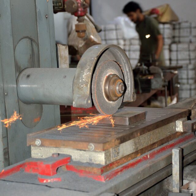 Sparks flying from a grinding machine as a padlock part is machined